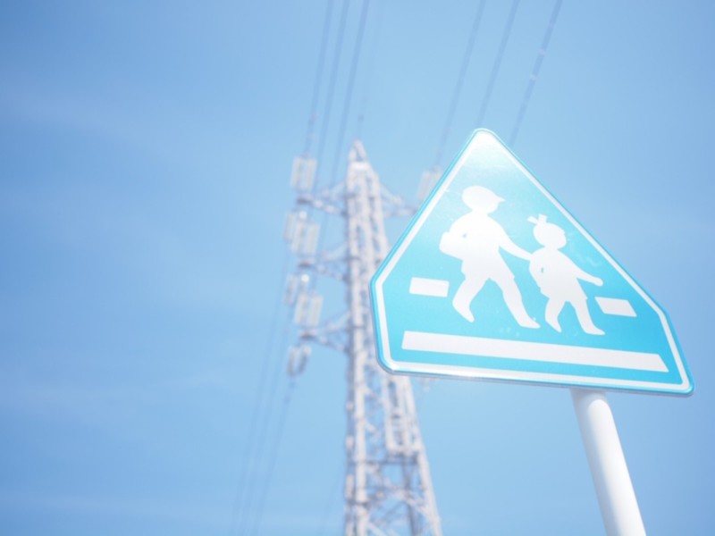 鉄塔と交通標識を青空をバックに